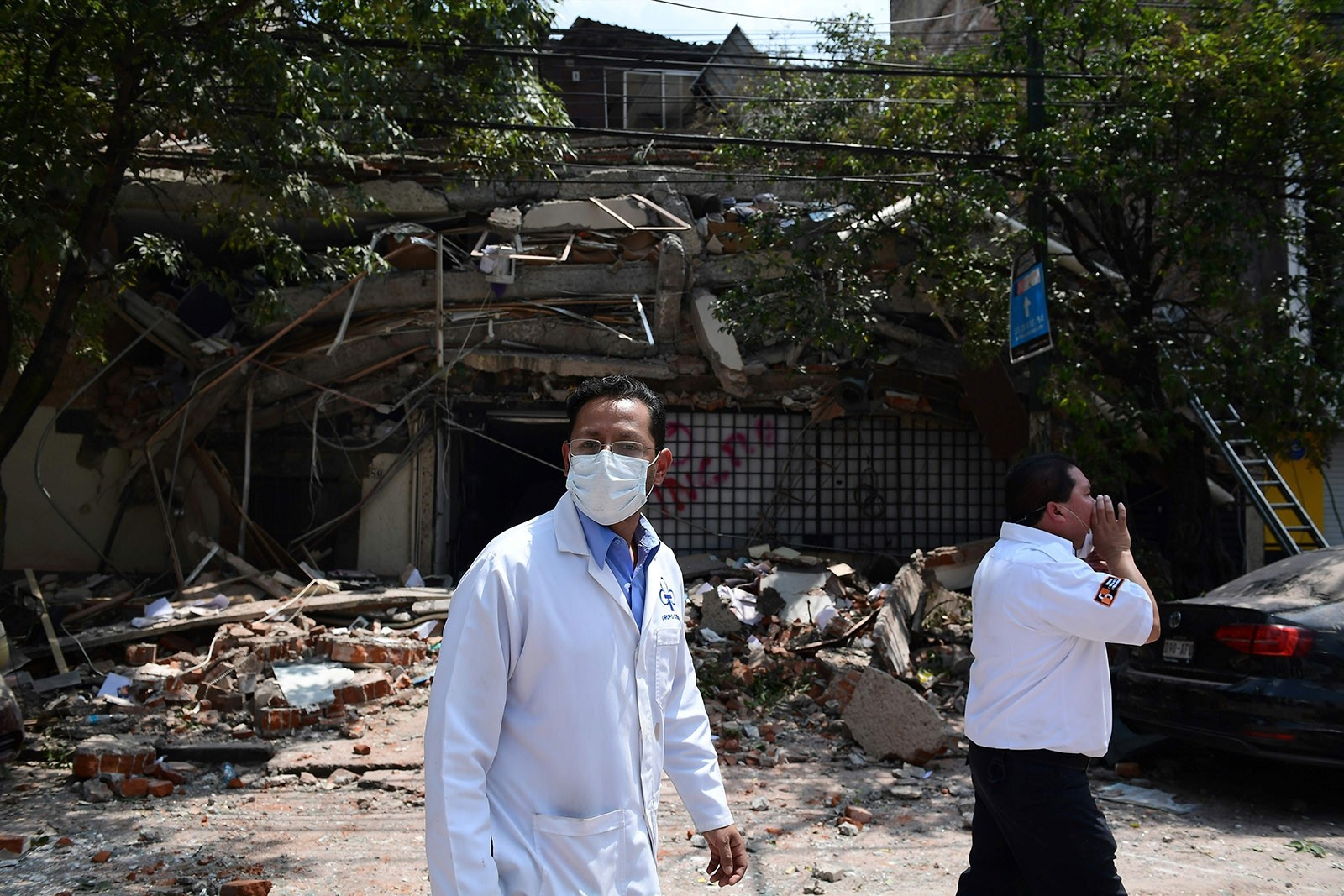 Medical staff walk by a building which collapsed during a quake in Mexico City on September 19, 2017. (AFP Photo)