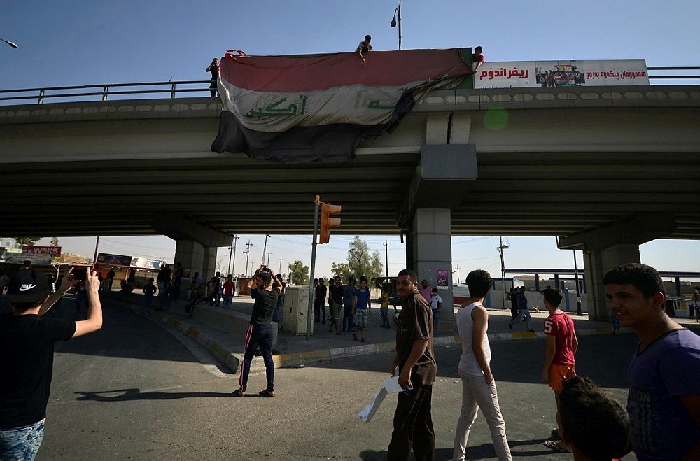 People hang a large Iraqi flag off a bridge in Kirkuk, Iraq, Oct. 16, 2017. (Reuters Photo) 