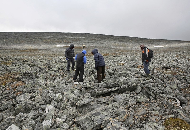 In this photo taken on Sept. 4, 2017, archeologists and the two hunters who found an ancient Viking sword, search the site where it was discovered on a mountain top (AP Photo)