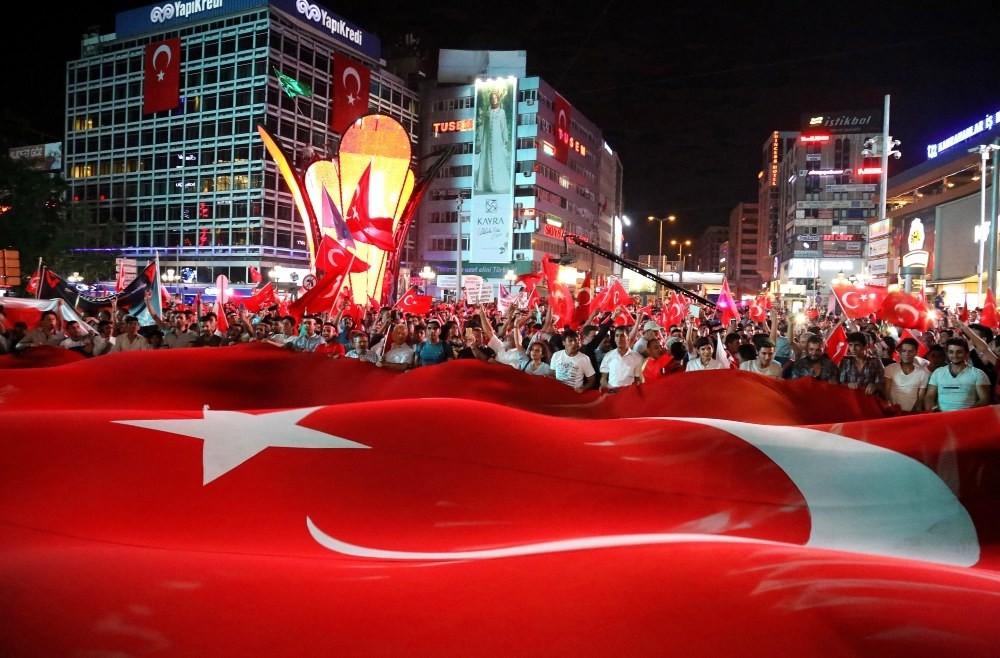 People hold a large Turkish flag during a march to mark the first anniversary of the coup attempt, Ankara, July 15. 
