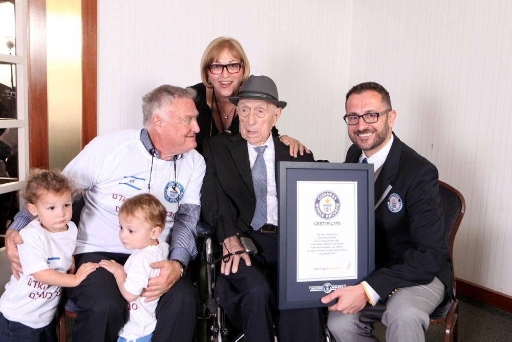 Picture released by Guinness World Records on March 11, 2016, Head of Records for Guinness World Records, presenting Israel Kristal (2nd-R) with his certificate. (AFP Photo)