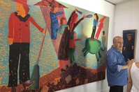 Artist u00d6zkan Gencer talks in front of his largest painting that sold for TL 12,000 at his solo exhibition at the gallery.
