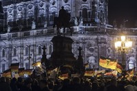 Pegida supporters, a German extremist, racist and Islamophobic group, hold German flags during a demonstration in front of the bronze equestrian statue of King John of Saxony, Dresden, Germany, Dec. 22, 2014. 