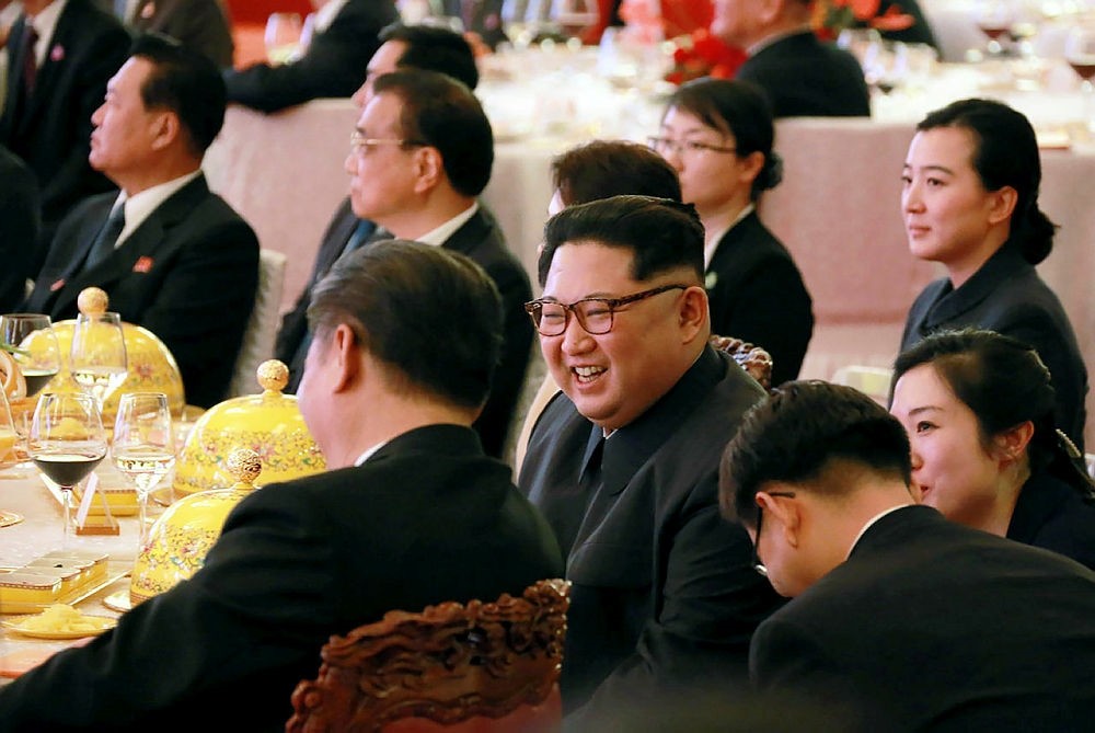 This picture from North Korea's official Korean Central News Agency (KCNA) taken on March 26, 2018 and released on March 28, 2018 shows North Korean leader Kim Jong Un (C) during a dinner banquet at the Great Hall of the People in Beijing.