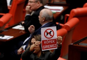 AK Party deputy Gökcen Özdoğan Enç shows a banner that reads 'no gods allowed.'