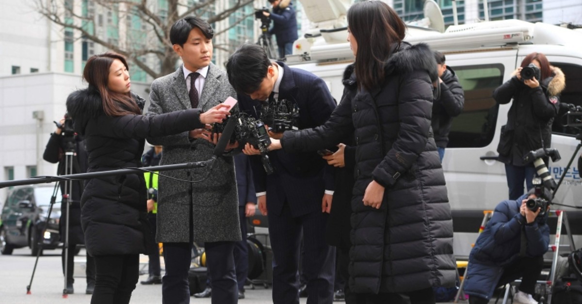 Seungri, center, member of a popular K-pop boy band Big Bang, bows on his arrival at the Seoul Metropolitan Police Agency in Seoul, South Korea, Thursday, March 14, 2019. (AFP Photo)