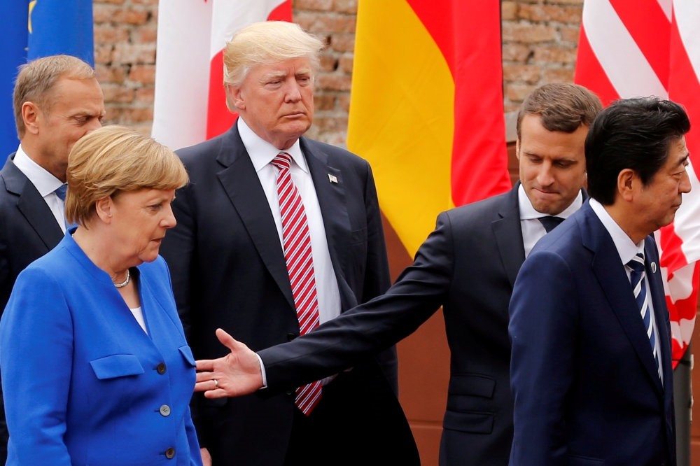 European Council President Donald Tusk, German Chancellor Angela Merkel, U.S. President Donald Trump, French President Emmanuel Macron and Japanese Prime Minister Shinzo Abe walk after a family photo during the G7 Summit in Italy.