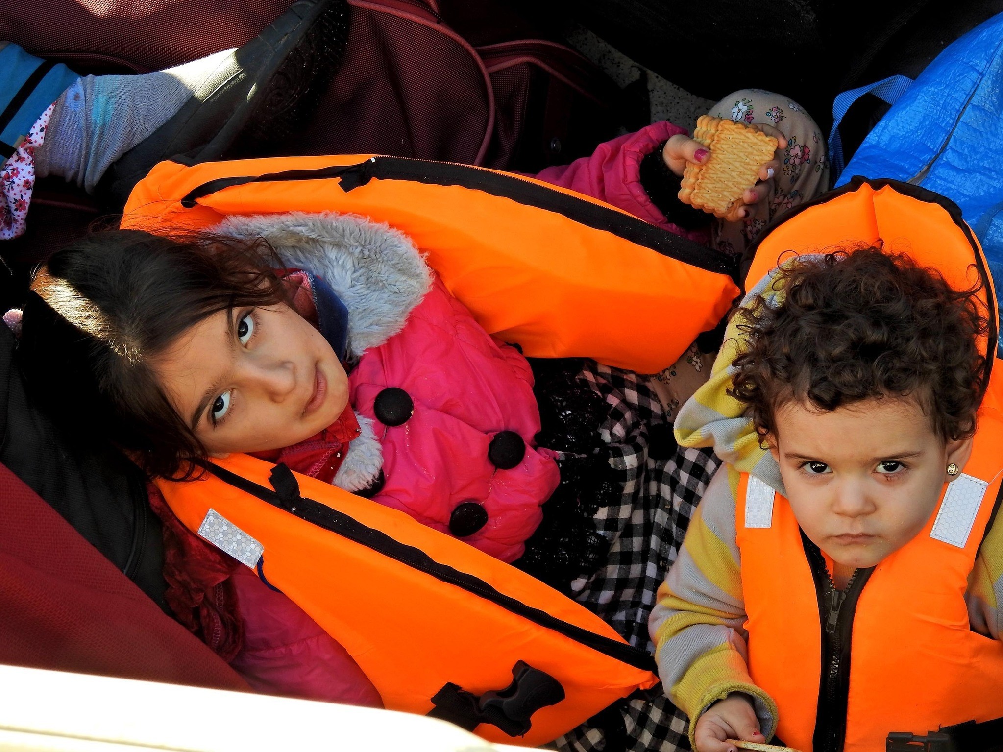 Two migrant children wait at the u00c7eu015fme port after they were brought there by the Coast Guard.