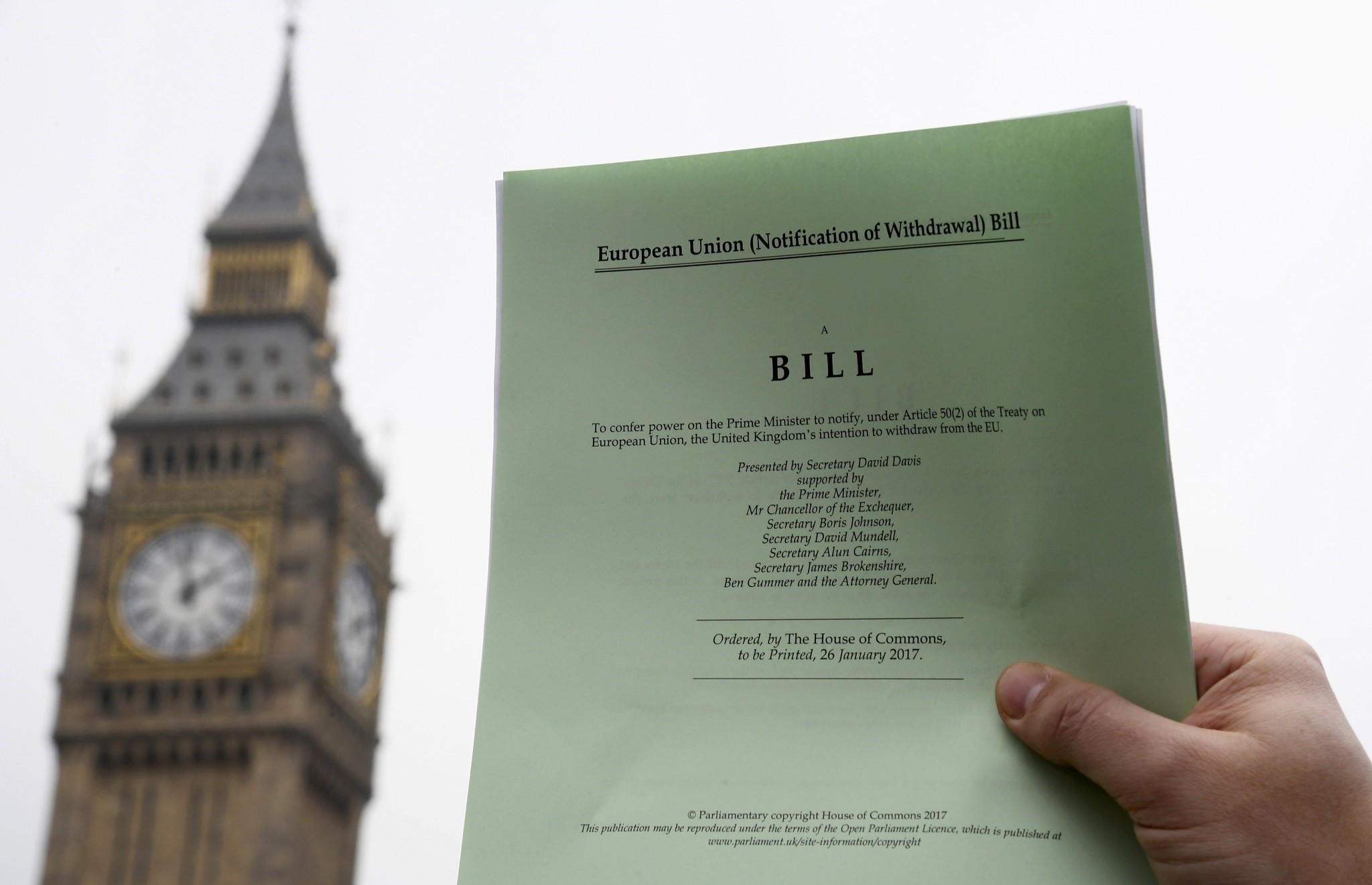 A journalist poses with a copy of the Brexit Article 50 bill, introduced by the government to seek parliamentary approval to start the process of leaving the European Union, in front of the Houses of Parliament in London, Britain, January 26, 2017.