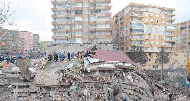 عمال إنقاذ ومتطوعون يجرون عمليات بحث وإنقاذ تحت أنقاض مبنى منهار جراء الزلزال في ولاية ديار بكر جنوب شرقي تركيا AFP