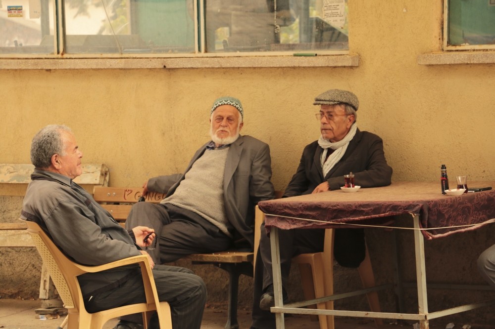 Producer and director Mehmet Tau015fdiken sitting with villagers.