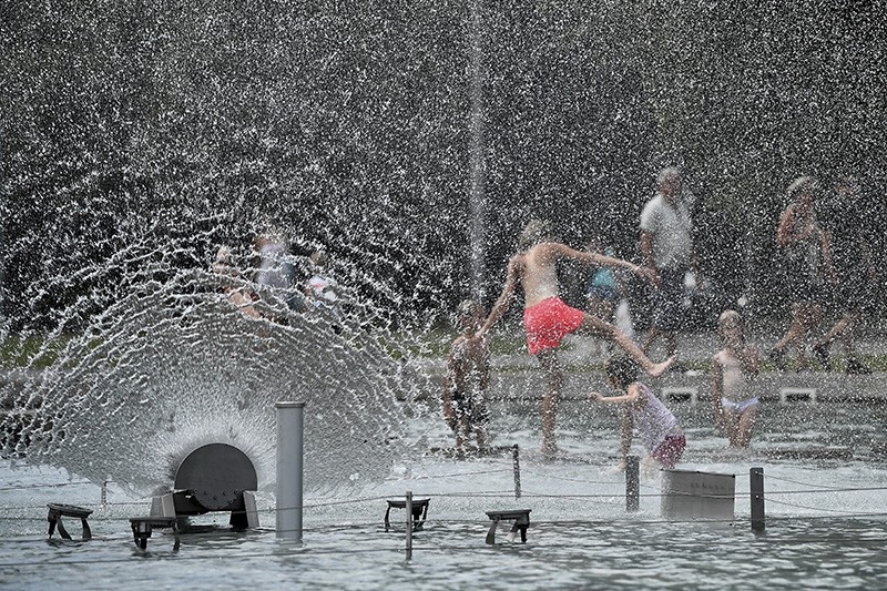 Children play in the water of a fountain to cool themselves in a square in Debrecen, 221 kms east of Budapest, Hungary, Tuesday, July 31, 2018. (AP Photo)
