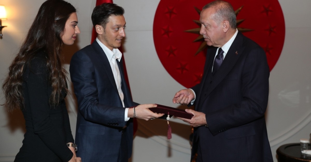 Mesut u00d6zil, center, and his fiancu00e9e Amine Gu00fclu015fe, left, give a wedding invitation to President Recep Tayyip Erdou011fan at the Atatu00fcrk Airport in Istanbul, March 15, 2019. (AA Photo)