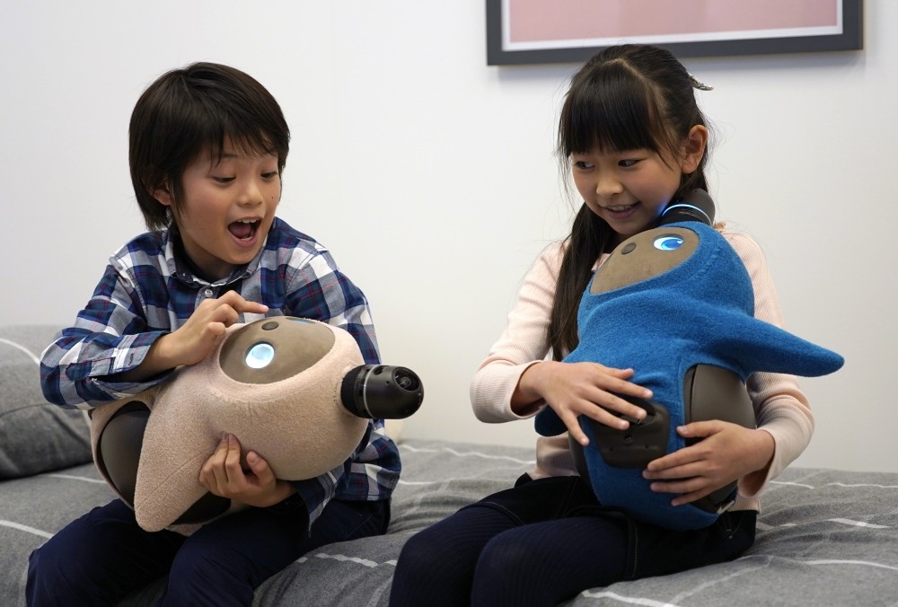 Children interact with GROOVE X's new home robots u2018LOVOT' during its presentation in Tokyo yesterday.