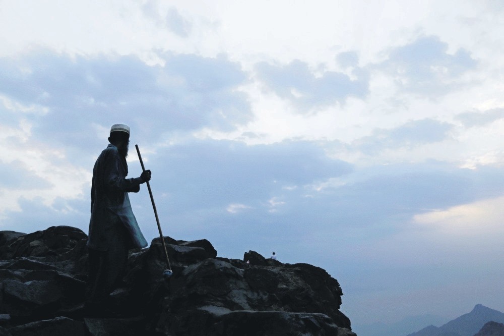 A Pakistani man cleans the Noon Mountain on the outskirts of Mecca, Saudi Arabia. 