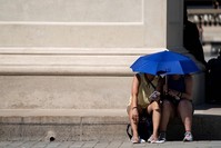 People use an umbrella to shelter from the sun near the Louvre Pyramid (Pyramide du Louvre) during a heatwave in Paris on June 26, 2019. (AFP Photo)