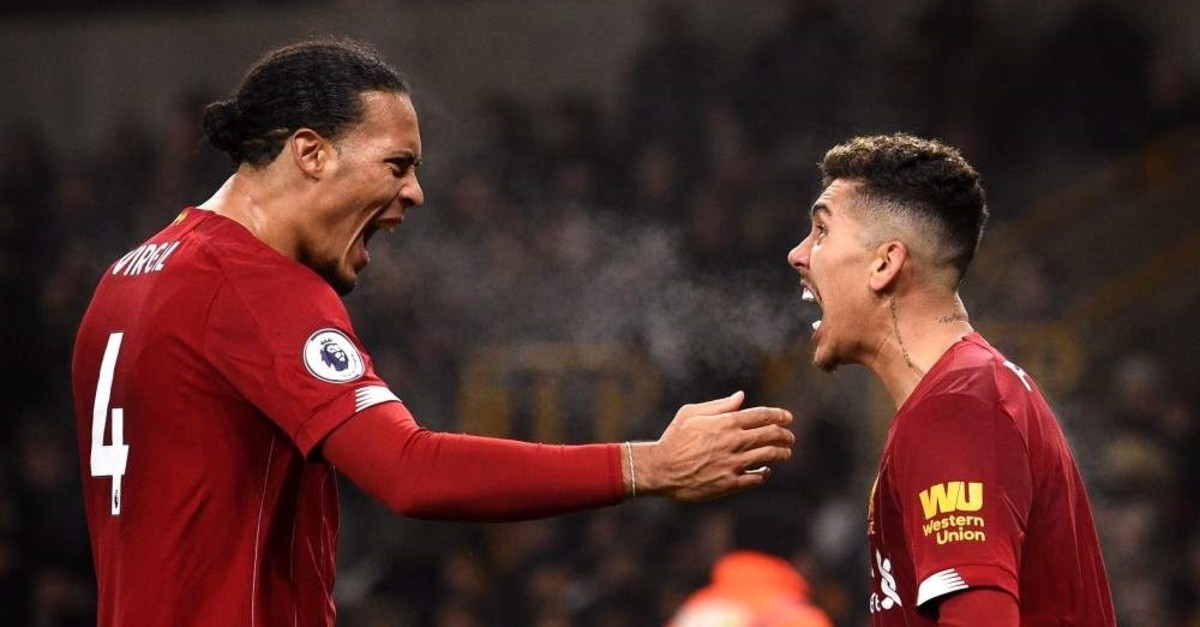 Liverpool's Virgil van Dijk (L) and Roberto Firmino celebrate the team's second goal against Wolves, Jan. 23, 2020.