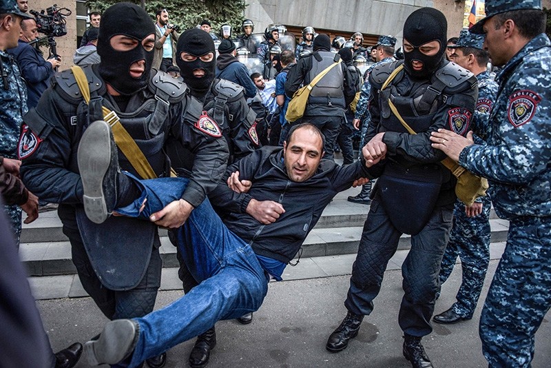 Armenian special police forces detain opposition supporters during their anti-government rally in front of the entrance to government headquarters in central Yerevan (AFP Photo)
