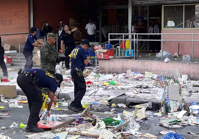 Members of the Philippine National Police (PNP) Scene of the Crime Operatives (SOCO) gather evidences on the site of an explosion on New Year's Eve outside a shopping mall in Cotabato City, southern Philippines, 31 December 2018. (EPA Photo)