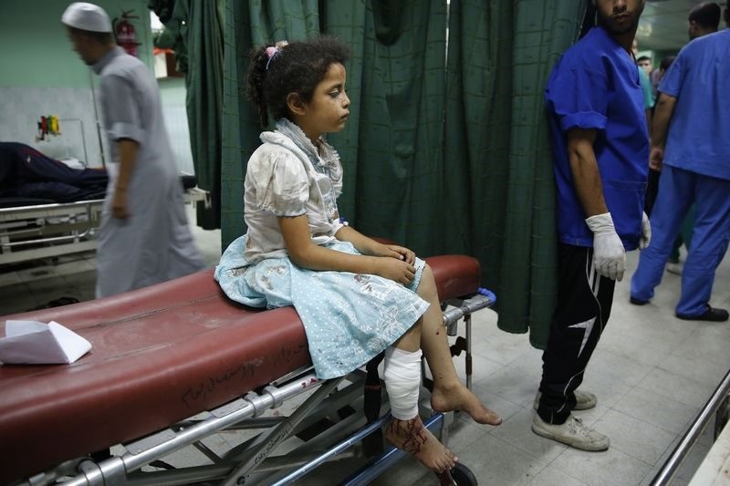 A Palestinian girl sits on a bed at a hospital in Beit Lahita in the northern Gaza Strip, July 30, 2014.