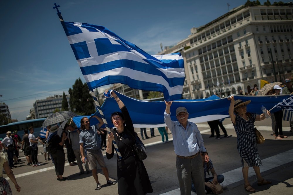People protesting the Macedonia name agreement, hold a Greek flag, Athens, June 15.