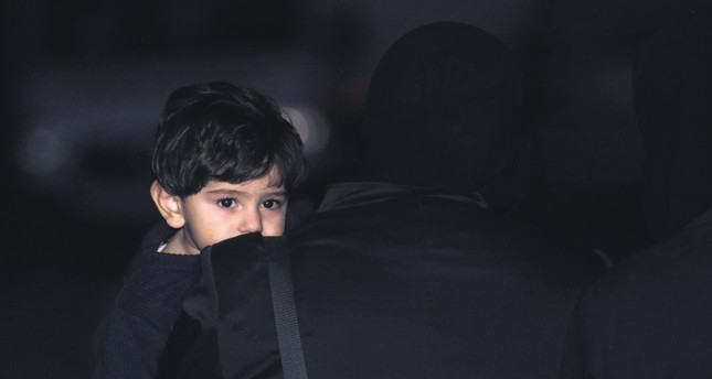 A child is carried following at Qalaat al-Madiq, some 45 kilometers northwest of the central city of Hama, after being evacuated from Eastern Ghouta, April, 2.