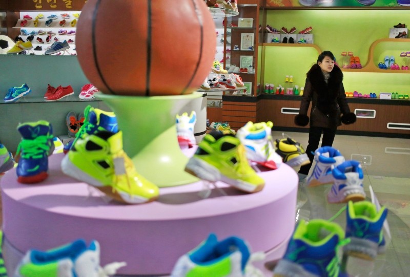 In this Friday, Feb. 1, 2019, photo, a guide stands near a basketball shoe display in a product exhibition room at the Ryuwon Shoe Factory that specializes in sports footwear, in Pyongyang, North Korea. (AP Photo)
