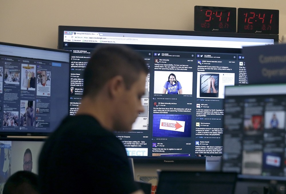 A man works at his desk in front of monitors during a demonstration in the war room, where Facebook monitors election related content on the platform, in Menlo Park, California.