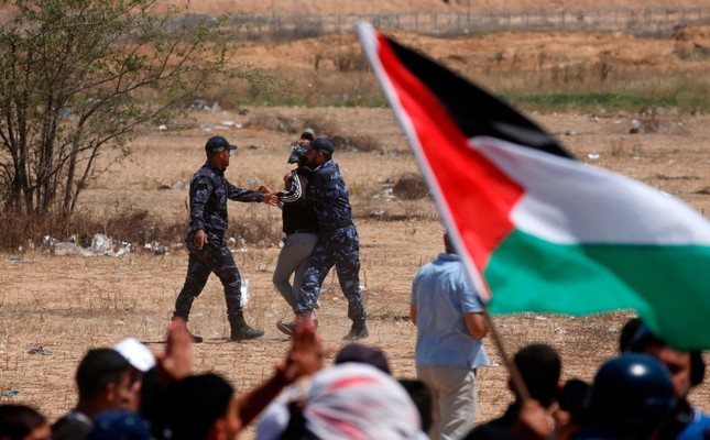 Palestinian Hamas police block protesters from reaching the border fence east of Khan Yunis in the southern Gaza Strip on May 15, 2019 (AFP Photo)