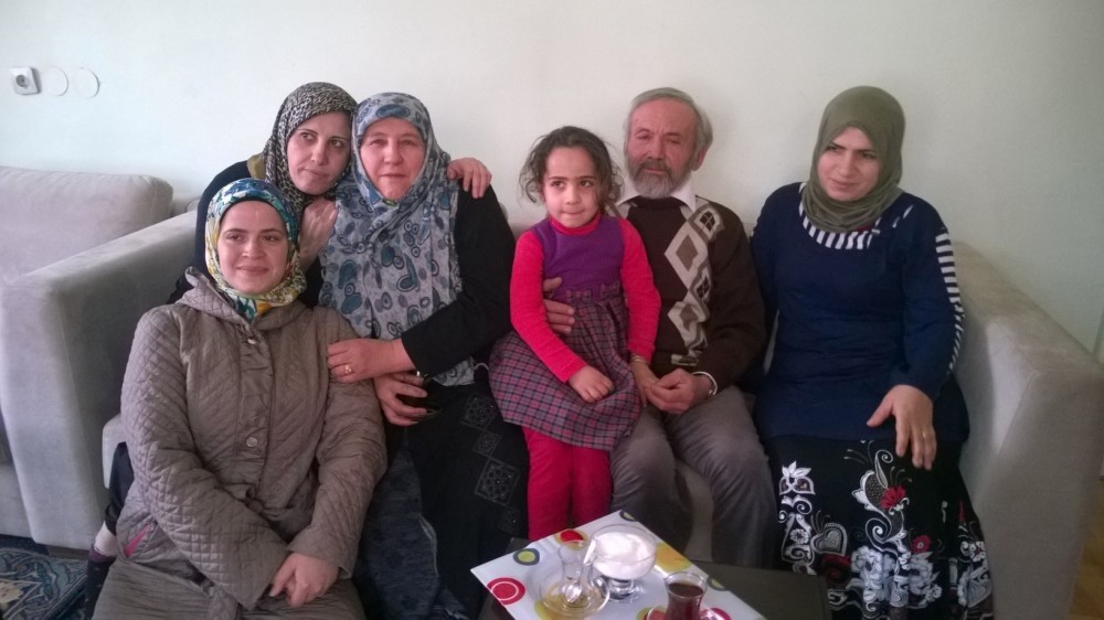 Cavit and Hafize Etleu00e7 pose with Syrian  refugees they help.