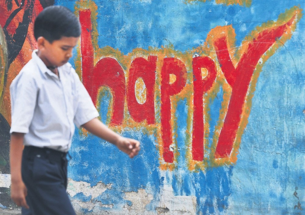 An Indian boy walks past graffiti in Mumbai.