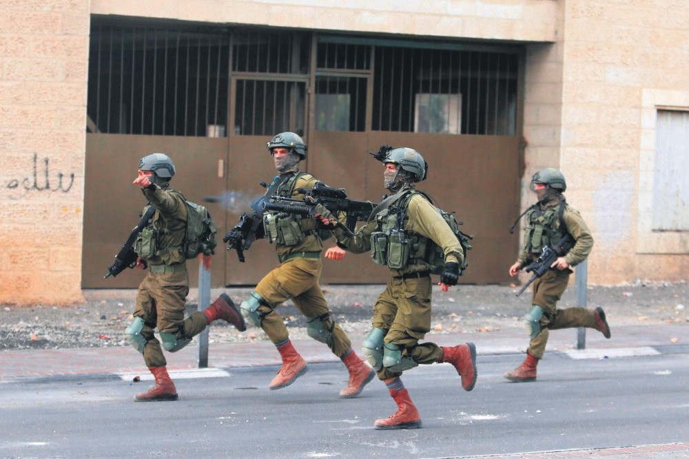 An Israeli soldier shoots tear gas towards Palestinians during a protest in the West Bank city of Bethlehem, Dec. 20.