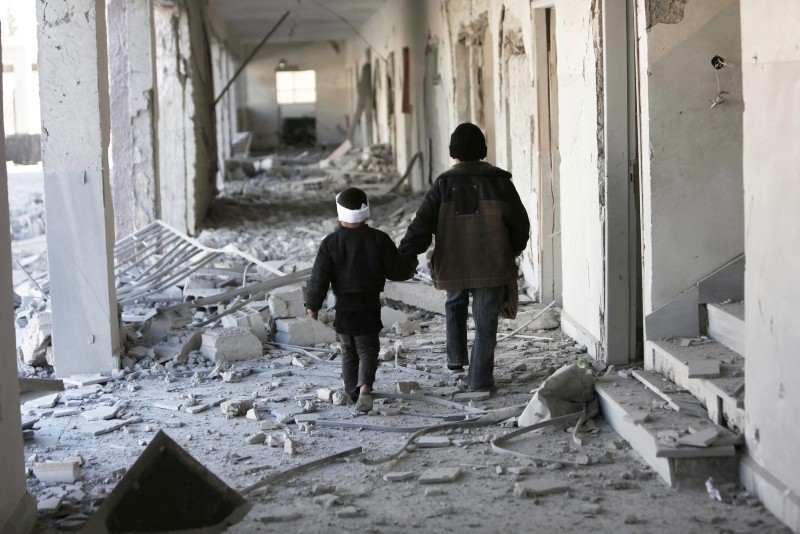 Two children walk through the corridors of a destroyed school in Eastern Ghouta, Syria. (Save the Children via AP)