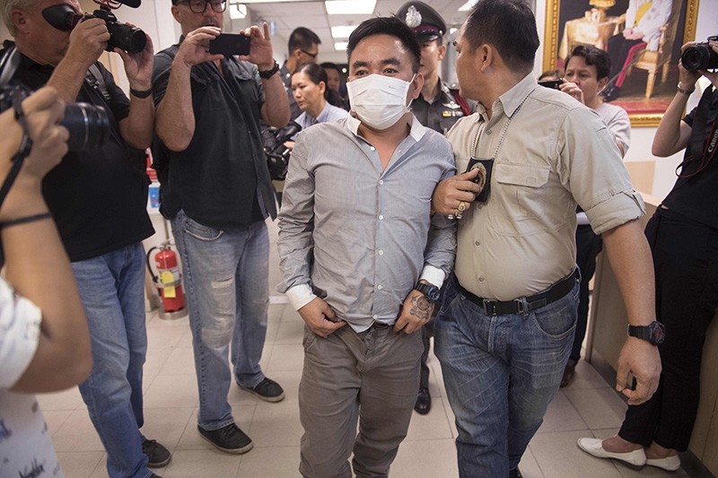 Boonchai Bach (C), 40, a Vietnamese national with Thai citizenship and alleged kingpin in Asia's illegal trade in endangered species, is escorted past journalists as he is processed at a police station in Bangkok on January 20, 2018. (AFP Photo)
