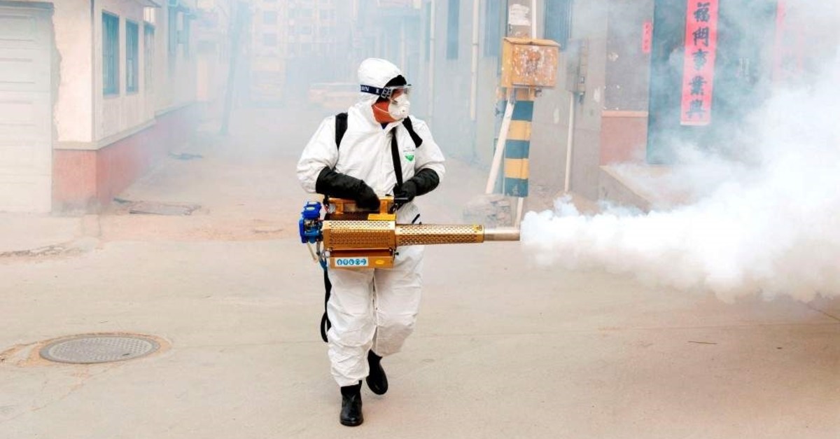 A worker in a protective suit disinfects the Dongxinzhuang village, Qingdao, Jan. 29, 2020. (REUTERS Photo)