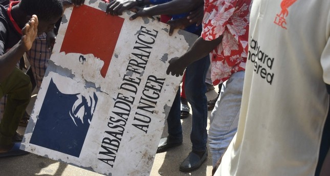 متظاهرون يحملون لافتة مأخوذة من السفارة الفرنسية في نيامي في مسيرة لدعم المجلس العسكري في النيجر في نيامي. 30 يوليو 2023 الفرنسية