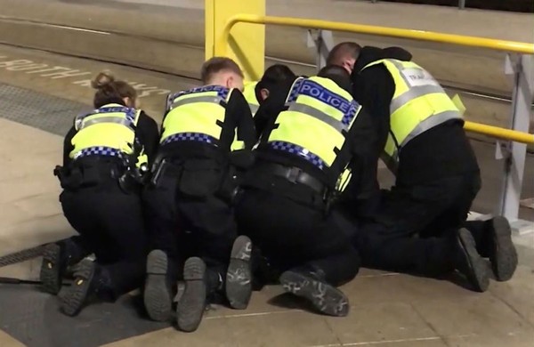 UGC issued by PA shows Police restraining a man after he stabbed three people at Victoria Station in Manchester, England, late Monday Dec. 31, 2018. (AP Photo)