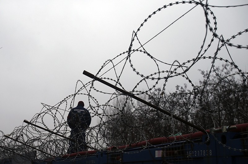 A Hungarian police officer stands guard at Serbia's border with Hungary near a makeshift camp for migrants in Horgos, Serbia, Wednesday, Feb. 8, 2017 (AP Photo)