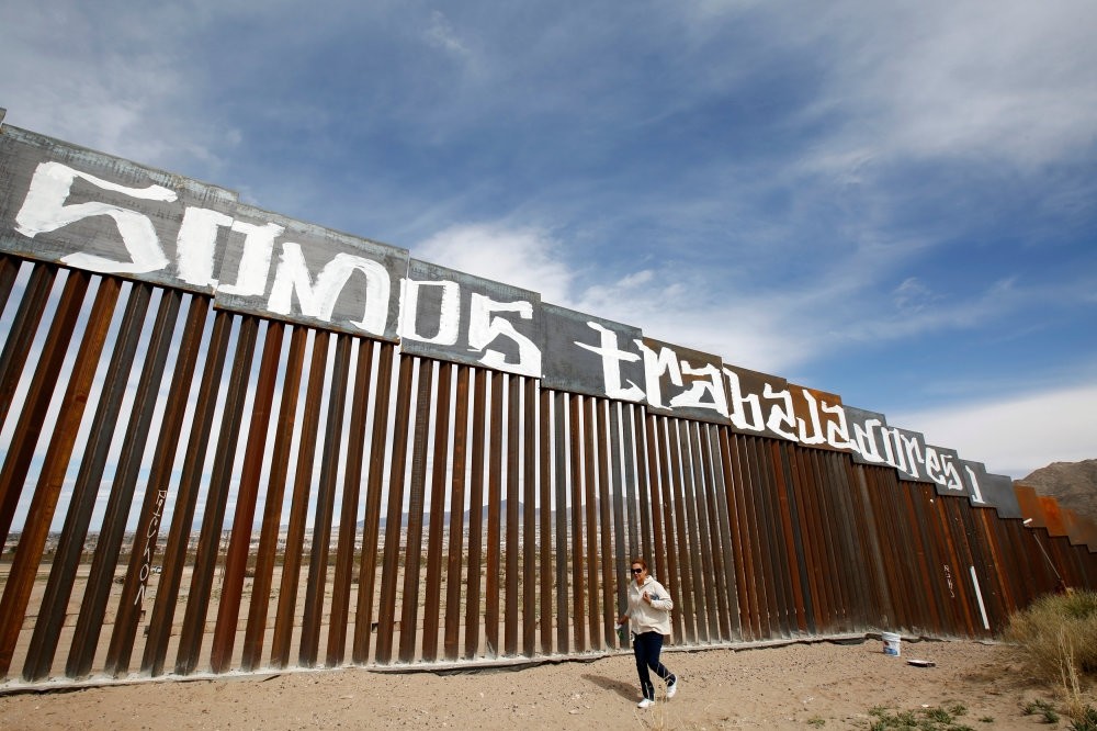A group of activists paint the U.S.-Mexico border wall between Ciudad Juarez and New Mexico as a symbol of protest against U.S. President Donald Trump's new immigration reform. The paint reads ,We are workers.,