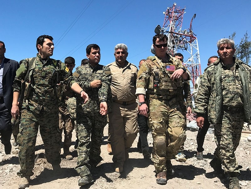 A U.S. military commander (2nd R) walks with militia from the People's Protection Units (YPG) at the YPG headquarters that was hit by Turkish airstrikes in Mount Karachok near Malikiya, Syria, April 25, 2017. (Reuters Photo)