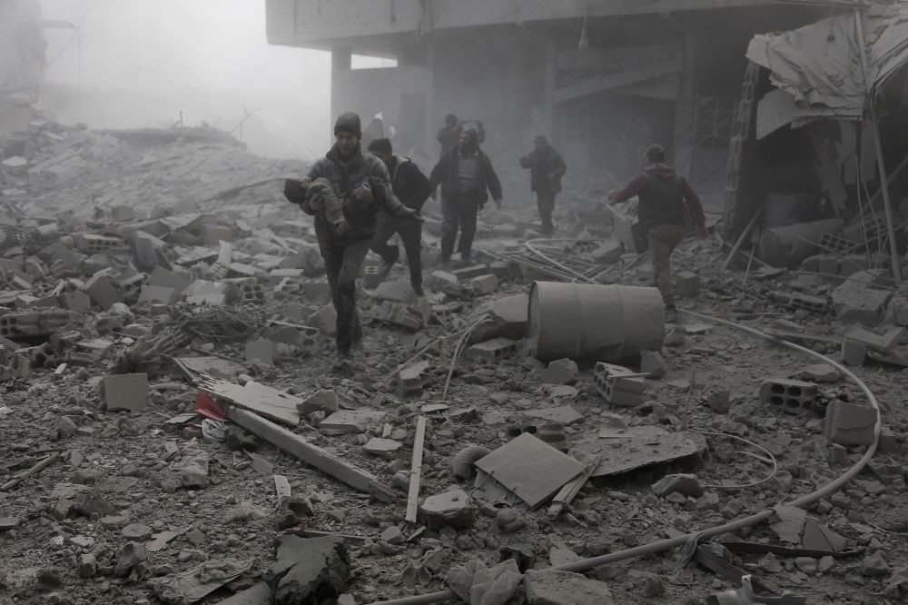 A man carries a child after digging him out of the rubble following an airstrike on Hamouria, in opposition-held eastern Ghouta, near Damascus, Jan. 9. 
