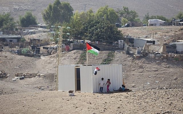 Palestinian girls stand by a newly made shed in the West Bank Bedouin community of Khan al-Ahmar, Sept. 11.