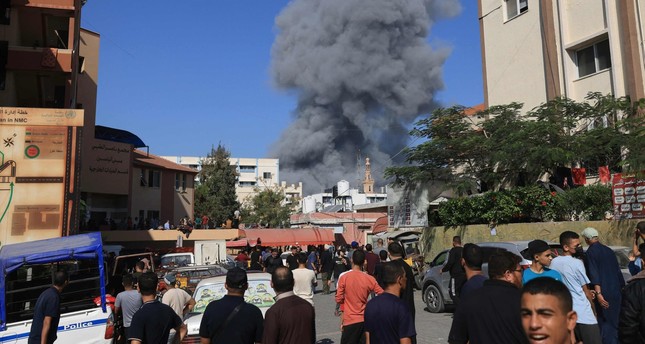 أشخاص يشاهدون تصاعد الدخان والغبار بعد القصف الإسرائيلي في خان يونس جنوبي قطاع غزة، فلسطين، 26-10-2023 صورة: AFP