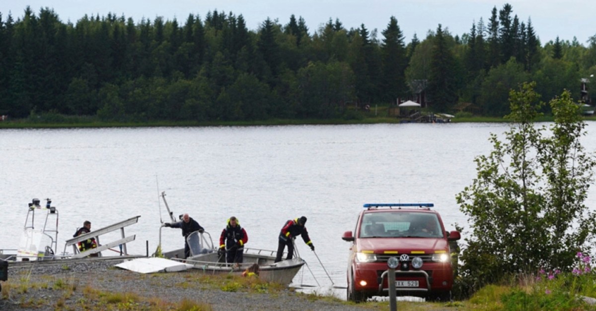 Emergency services attend the accident site at a small harbor at Ume river, outside Umea, Sweden, Sunday July 14, 2019. (AP Photo)
