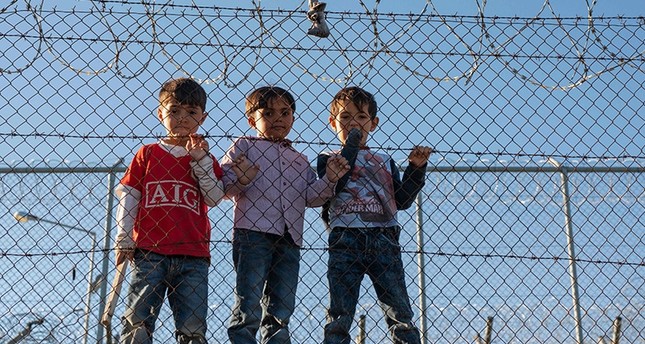 Children stand behind a fence inside the Moria refugee camp on Lesbos Island on Nov. 8, 2018. (AFP Photo)