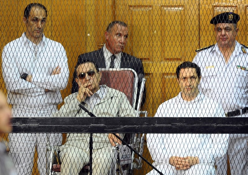 In this Sept. 14, 2013 file photo, former Egyptian President Hosni Mubarak, seated center left, and his two sons, Gamal Mubarak, left, and Alaa Mubarak attend a hearing in a courtroom in Cairo, Egypt. (AP Photo)