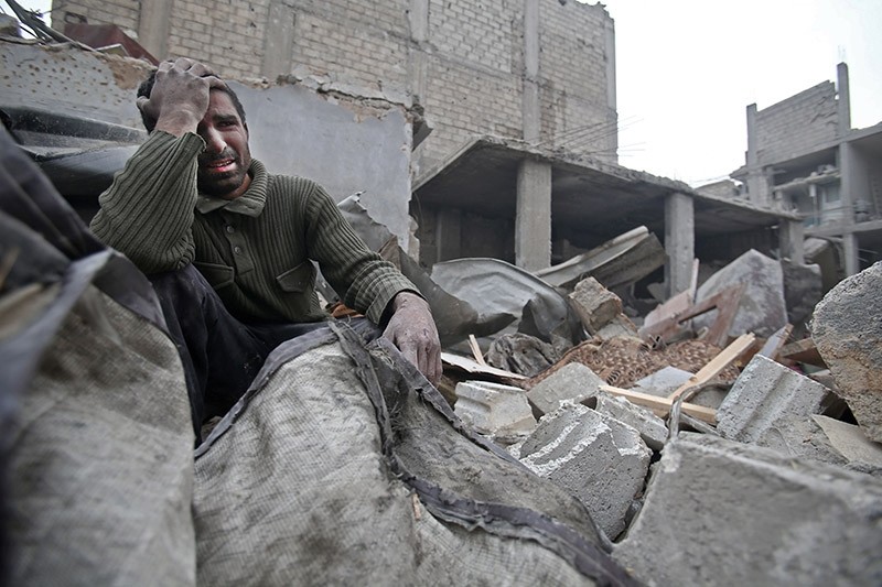 A Syrian man mourns over his destroyed home in the rebel-held besieged town of Arbin, in the eastern Ghouta region on the outskirts of the capital Damascus on February 5, 2018, following airstrikes. (AFP Photo)