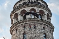Turkish extreme sports athlete Cengiz Kocak performs a base jump off Galata Tower in Istanbul on November 9, 2017, as part of the events organised by European Outdoor Film Tour (EOFT) in Istanbul (AFP Photo)