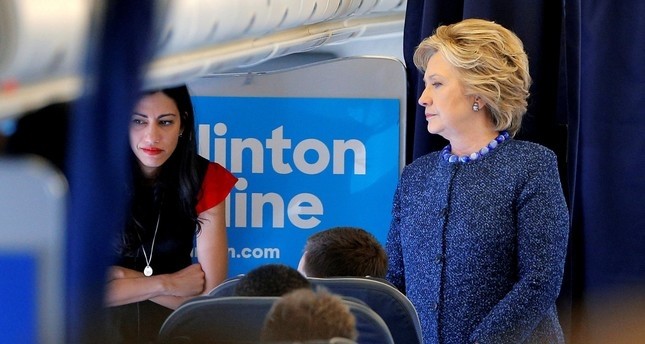 U.S. Democratic presidential nominee Hillary Clinton talks to staff members, including aide Huma Abedin (L), onboard her campaign plane in White Plains, New York, U.S. October 28, 2016. (REUTERS Photo)