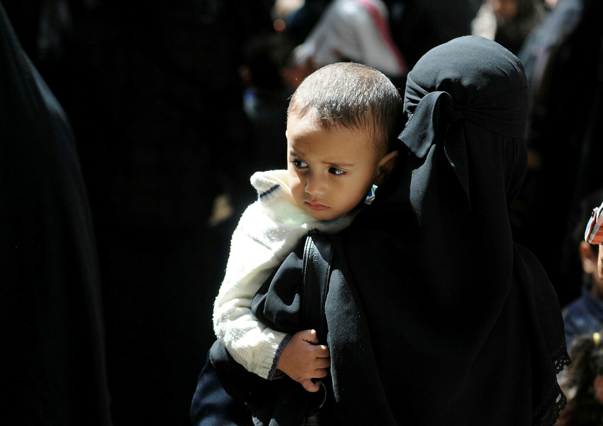Yemeni woman waits to get her children vaccinated against diphtheria at a health center in Sanaa, March 13.